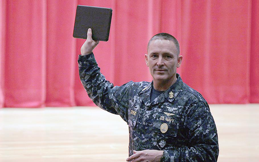 Master Chief Petty Officer of the Navy Michael D. Stevens holds up a tablet computer during an all-hands call at Yokosuka Naval Base, Japan, on April 23, 2014. Stevens told the audience that new Navy recruits will be issued one in bootcamp to keep up with trends in technology.