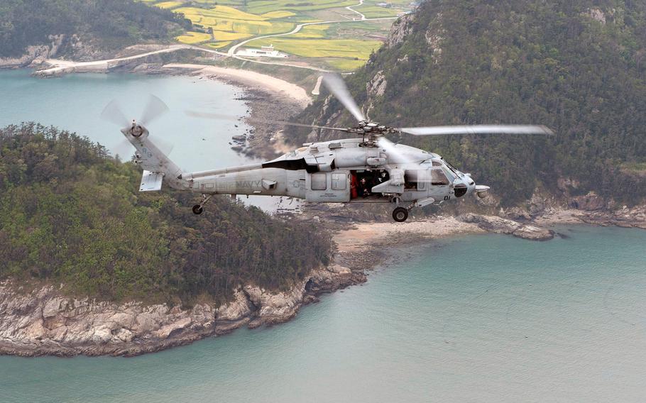 An MH-60S Sea Hawk helicopter from the amphibious assault ship USS Bonhomme Richard conducts search and rescue operations as requested by the South Korean navy near the scene of the sunken ferry Sewol in the vicinity of the island of Jindo.
