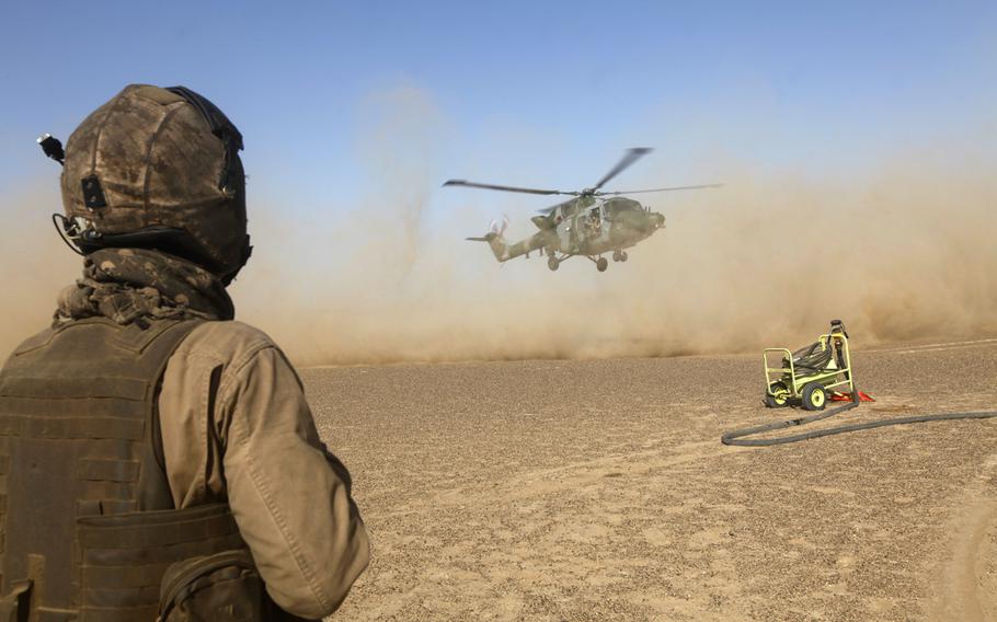 A U.S. Marine Corps crew chief watches a British Lynx 9A land in Helmand province, Afghanistan, Dec. 11, 2013.