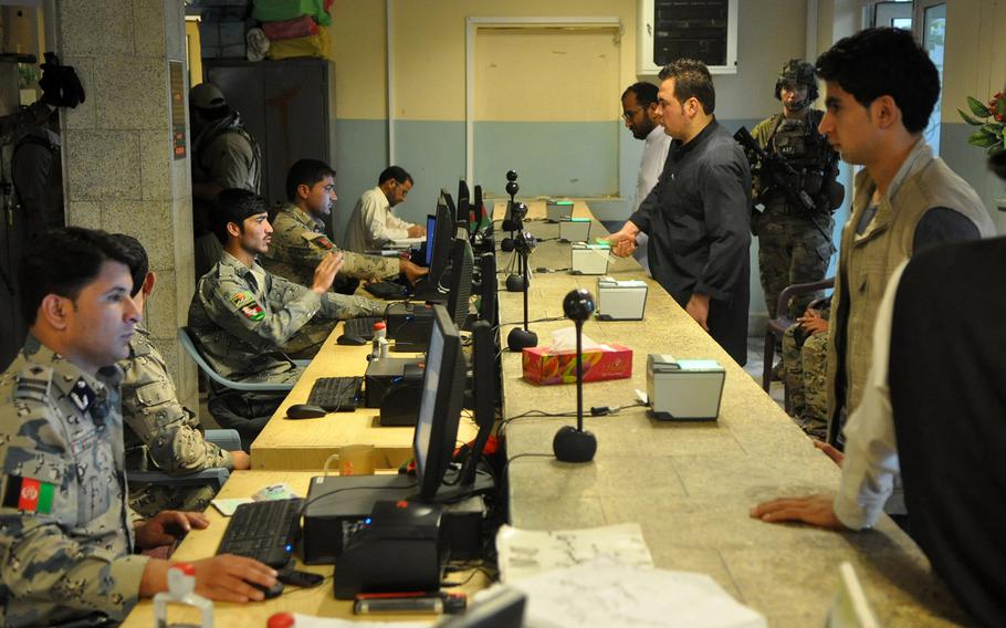 Afghan Border Police officers check passports and collect fingerprints and other personal information from travelers crossing the border with Pakistan at Torkham Gate in eastern Afghanistan in May 2013. The electronic equipment often sits idle for hours in the mornings and evenings because of a lack of electricity.
                