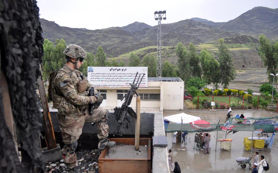 Sgt. Antoni Jedra, with 1st Battalion, 327th Infantry Regiment of the 101st Airborne Division, watches as people pass through the Torkham Gate crossing on the border of Afghanistan and Pakistan in May 2013. 
                
