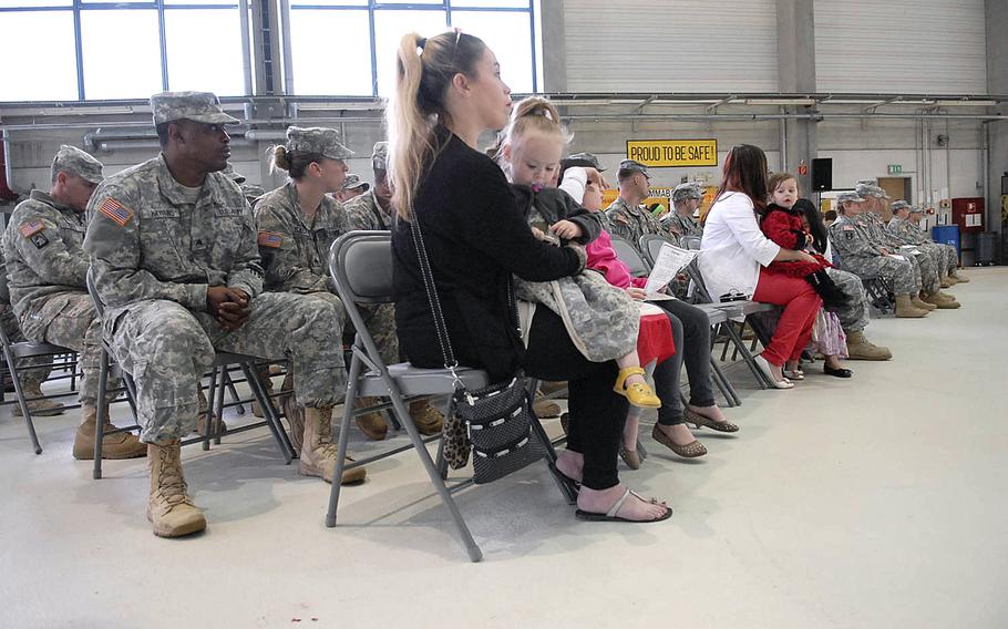 Army spouse Justine Bateson sits in the front row with her three children during a deployment ceremony Wednesday, April 30, 2014, for soldiers with Company C, 1st Battalion, 214th Aviation Regiment at Landstuhl Army Heliport in Germany.