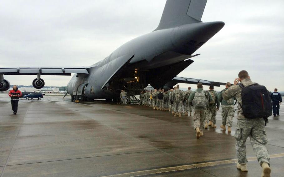 Members of Oregon's joint-service Air and Army National Guard board for a flight to Joint Base Elmendorf-Richardson, Alaska, April 24, 2014.