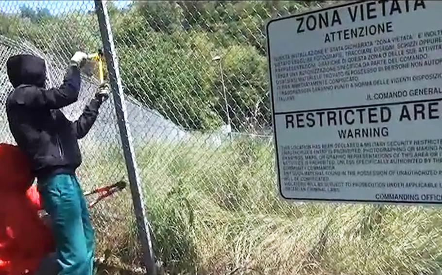 In a screen capture from the video posted by the so-called NoDalMolin movement, intruders cut through the fence to gain access to Tormeno Ammunition Storage Point 7 at Arcugnano, Italy.