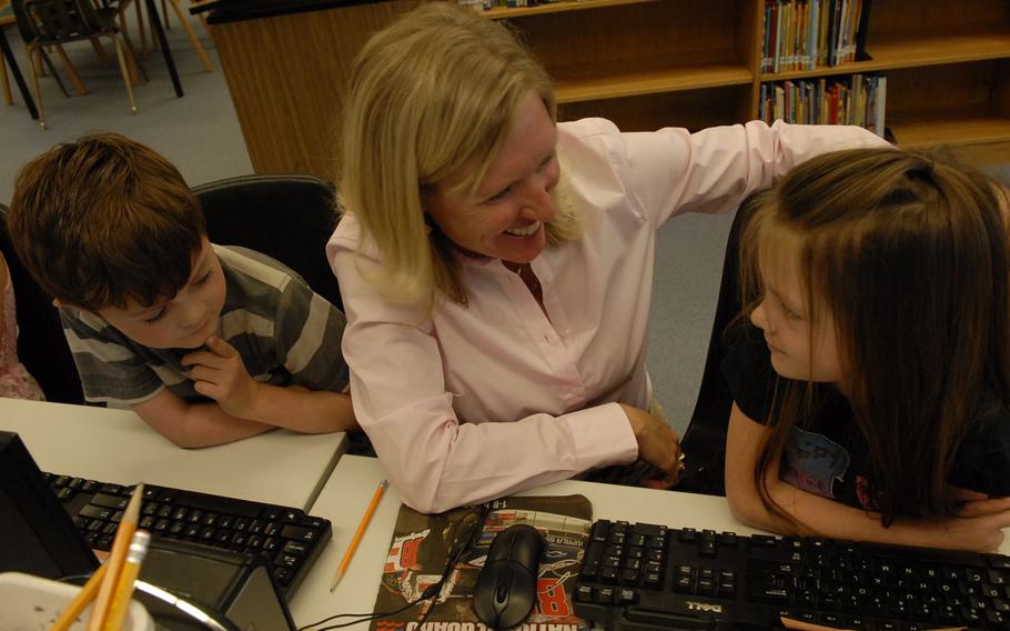 Sarah Loomis talks with Kaiserslautern Elementary School kindergarten students Grace Deiber and Michael Hamlett. Loomis, an educational technologist at the school in Germany, was recently named the Department of Defense Education Activity teacher of the year.