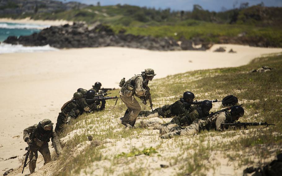 Two Japan Ground Self-Defense Force soldiers (left and center) advance to cover while their squads provide cover during an amphibious assault at Pyramid Rock Beach. The JGSDF conducted the training exercise with U.S. Marines with 3rd Reconnaissance Battalion, based in Okinawa, Japan.