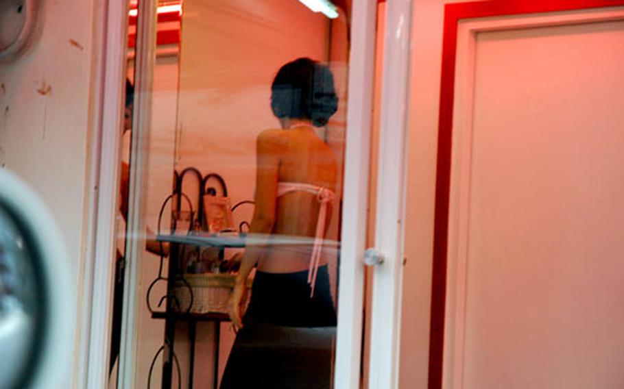 A woman stands in a window along a 'red-light' strip just outside of Yongsan Station in Seoul in this undated file photo. A group of former prostitutes has filed a lawsuit against the South Korean government seeking more than $1.2 million in compensation.