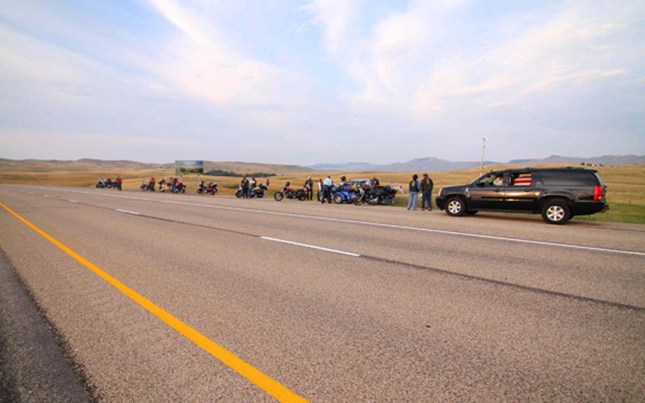 A flag-draped casket carrying the remains of Army Pfc. Lawrence Gordon can be seen in the back of the sport utility vehicle. Beginning Aug. 8, 2014, Gordon's remains were escorted by Patriot Guard members and local law enforcement as their way through five states and over the border into Canada en route to his final resting place.