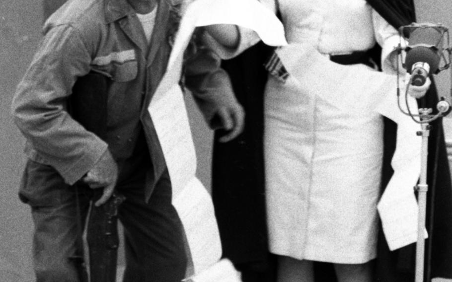 Kaye Stevens, playing an Army nurse conducting sick call (hours: 8 to 8:05 a.m.), presents patient Bob Hope with a questionnaire to be filled out before he can be treated. Hope: "Thank heavens it's the short form." The sketch was part of Hope's 1965 Christmas tour for U.S. troops in Asia.