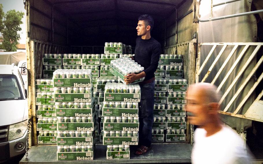 A liquor store worker unloads cases of Heineken beer in the Ankawa district of Irbil, capital of Iraqi Kurdistan on Aug. 20, 2014.
                