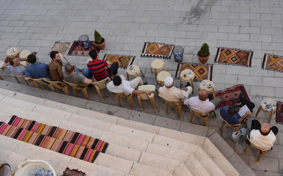 Kurdish men drink tea and visit at the base of the Irbil Citadel in the center of the capital of Iraqi Kurdistan, Aug. 25, 2014.
                