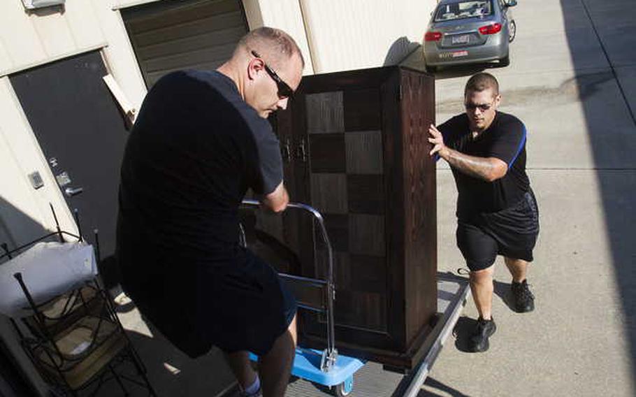 Aerographer's Mate Kirk Hying, left, and Sean Mitchell work together to load a cabinet on to a rental truck while volunteering with Crusaders for Veterans Inc. in this undated file photo. The volunteers were assisting homeless veteran Brenda Chorba move into a new home after she spent the past 14 months living in her car.