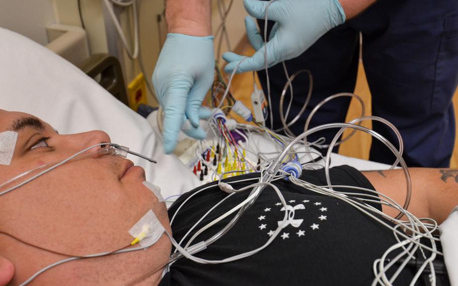 U.S. Army Sgt. 1st Class Bobby M. Scharton, a platoon sergeant with 17th Fires Brigade, 7th Infantry Division, lies down as Christopher Taylor, a sleep technician with Madigan Army Medical Center, checks sensor connections during a sleep study at Joint Base Lewis-McChord, Wash., on Nov. 22, 2013. A team of researchers at the hospital have proposed creating a new diagnosis for sleep disorder brought on by trauma.