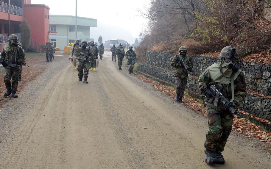 Soldiers with Company A, 1st Battalion, 72nd Armor Regiment, 1st Armored Brigade Combat Team, 2nd Infantry Division, and Republic of Korea soldiers escort a 2ID chemical reaction team during training at Rodriguez Live Fire Complex, South Korea, on Nov. 15, 2013.