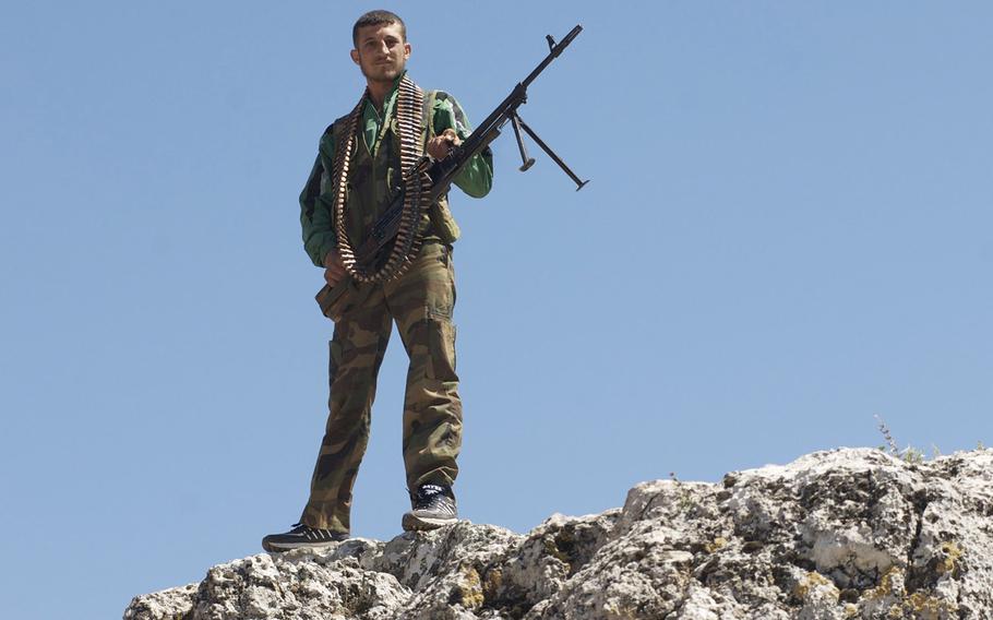 A Free Syrian Army member stands guard over an FSA base in central Syria, June 6, 2012.