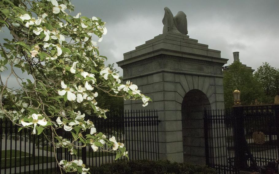 The blossoms of a dogwood tree frame an entrance to Arlington National Cemetery. A bill aimed at decreasing recent delays in veteran burials by giving Congress new VA oversight got a push forward from lawmakers Thursday, Nov. 20, 2014.