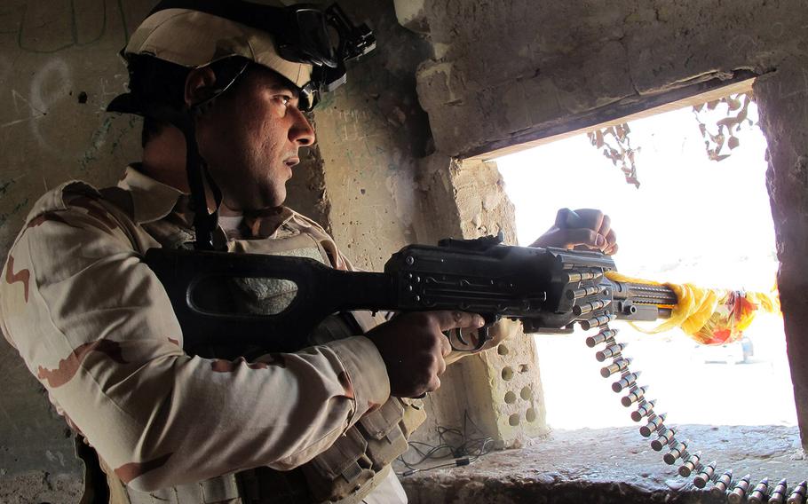 In this Nov. 2014 file photo, Iraqi Army Sgt. Ahmed Hassan stands sentinel in an guard tower in Abu Ghraib, where the army and allied Shiite militiamen were struggling to hold the town and nearby Baghdad International Airport.