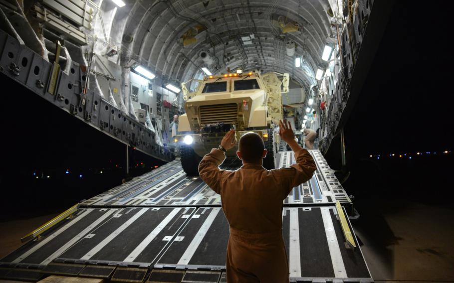 Airmen load two mine resistant armored personnel carriers on a C-17 Globemaster III bound for Erbil, Iraq, Dec. 30, 2014.