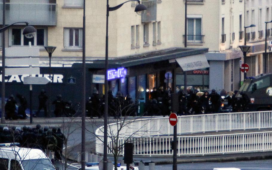 French security forces storm a kosher supermarket in Paris on Friday, Jan. 9, 2015, where a gunman had taken several hostages. 