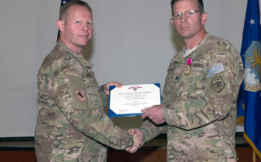 Air Force Col. Joseph D. McFall, left, presents the Legion of Merit to Col. Kelly S. Passmore, at a change of command ceremony on June 10, 2014, at Camp Lemonnier, Djibouti. 