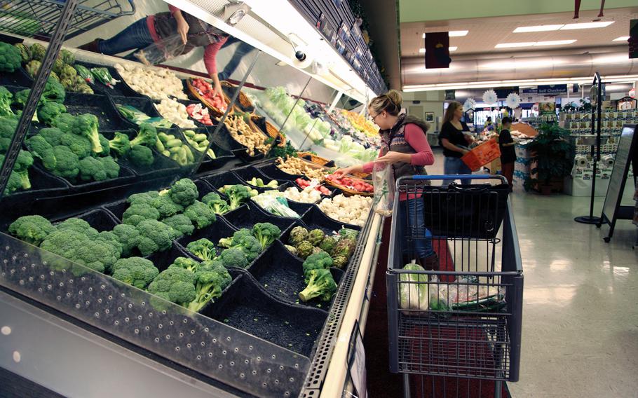 In this file photo from Jan. 8, 2013, military family member Amber Korpalski selects vegetables from the produce section of the commissary at Camp Foster, Okinawa, Japan.