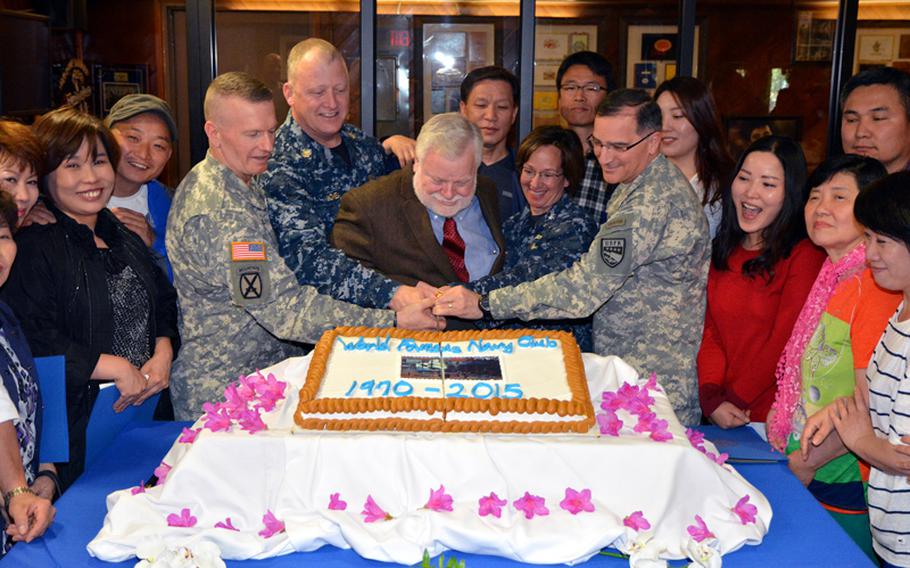Gen. Curtis Scaparrotti, commander of U.S. Forces Korea; Rear Adm. Lisa Franchetti, commander of U.S. Naval Forces Korea; Randy Quimby, director of the Navy Club; U.S. Naval Forces Korea Command Master Chief James Honea; and Command Sgt. Maj. John Wayne Troxell, command sergeant major of U.S. Forces Korea cut a cake in front of former employees and guests during a closure ceremony for the Navy Club at the U.S. Army Garrison Yongsan in Seoul, Thursday, May 7, 2015.