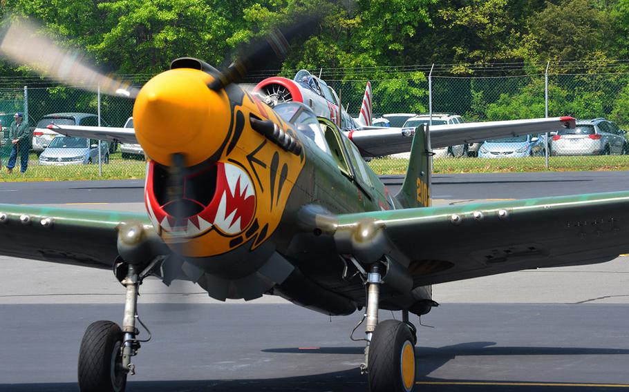 A pilot waves Thursday, May 7, 2015 in Culpeper, Va., after landing his plane at the preview for the Arsenal of Democracy: World War II Victory Capitol Flyover.