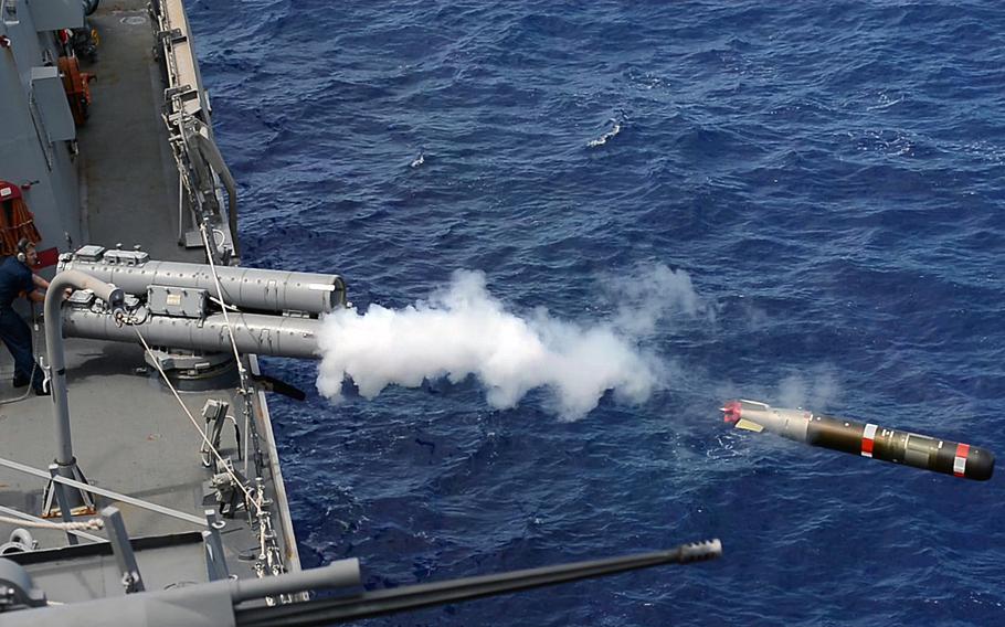 The Arleigh Burke-class guided-missile destroyer USS Mustin fires a torpedo at a simulated target during Valiant Shield 2014 in the Pacific Ocean.
