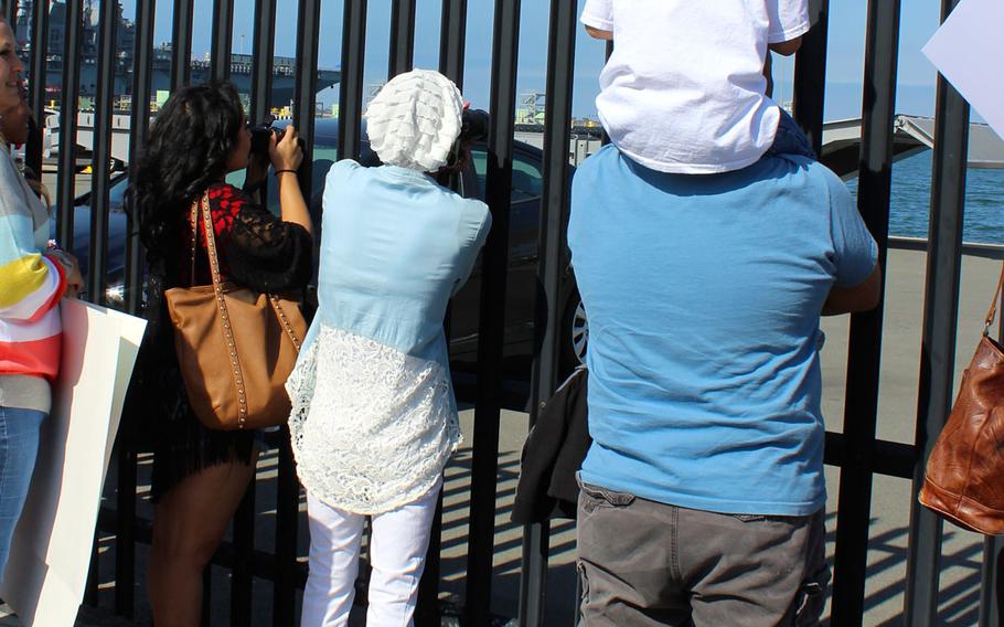 Families wait on the pier at Naval Base San Diego on Monday, June 1, 2015, to welcome home the crew of the Navy destroyer USS Sampson. The ship left on Halloween for a deployment to the Western Pacific.