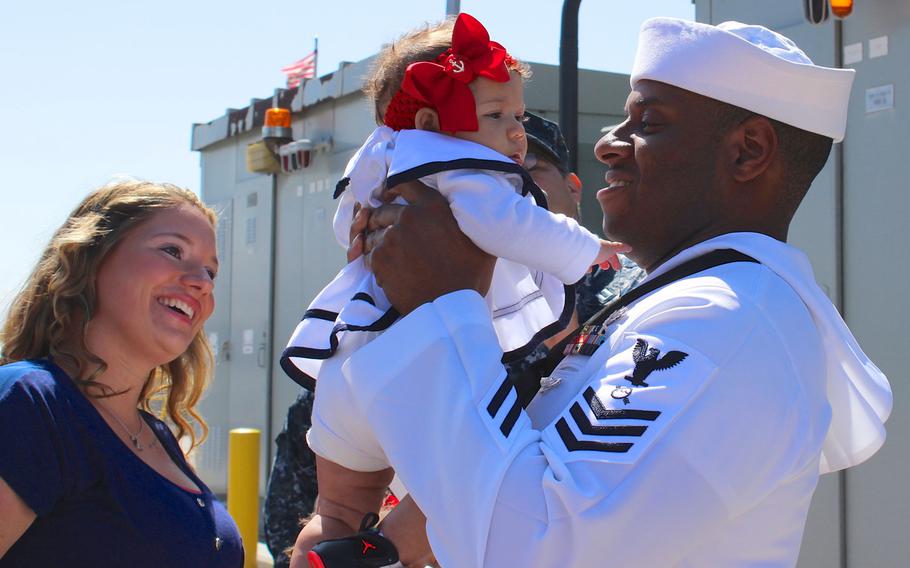 A sailor greets his new daughter for the 1st time Monday morning, June 1, 2015, after returning to Naval Base San Diego from a 7-month deployment aboard the USS Sampson.