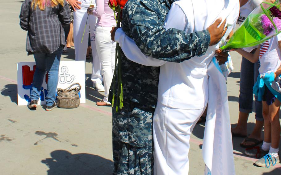 A sailor embraces his wife after her return to Naval Base San Diego on Monday, June 1, 2015, from a 7-month deployment aboard the USS Sampson.
