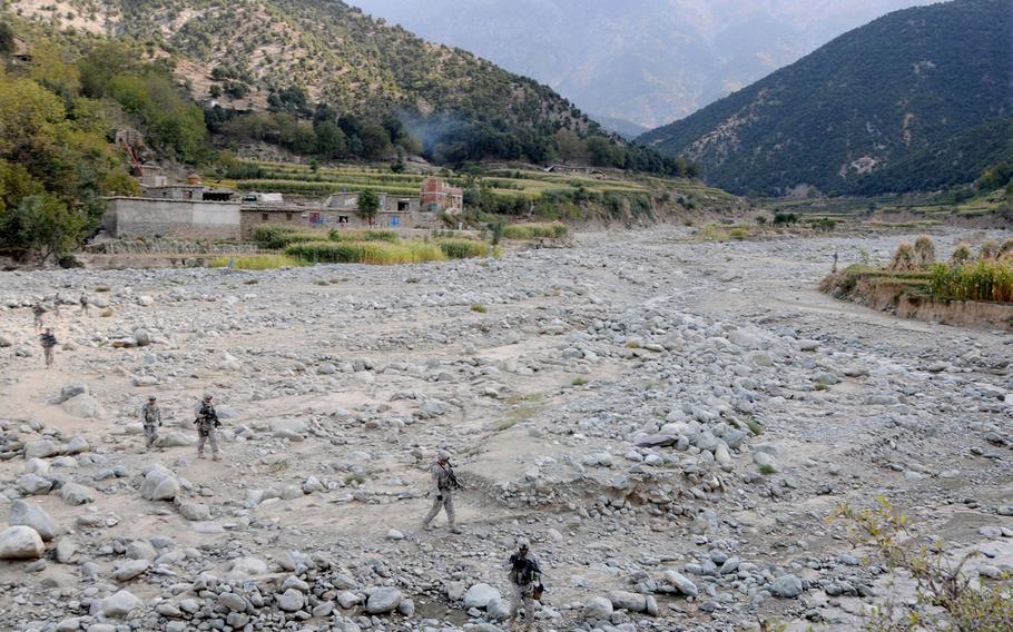 Provincial Reconstruction Team Kunar security force members cross a river bed on their way to the Dangam District Center in Kunar province in this Oct. 22, 2009, photo. 