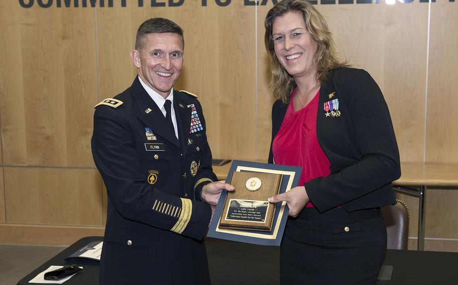 Retired Navy SEAL Kristin Beck, born Christopher T. Beck, receives a plaque from DIA Director Lt. Gen. Michael Flynn following the agency's Pride Month event June 18, 2014.
                