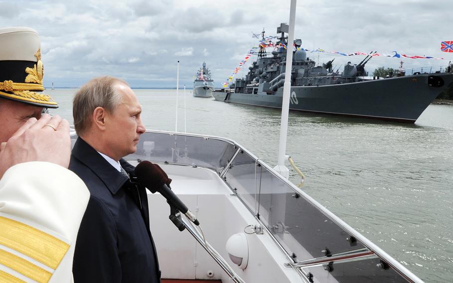 Russian President Vladimir Putin, second left, reviews a Navy parade in Baltiisk, western Russia, Sunday, July 26, 2015 during celebrations for Russian Navy Day.