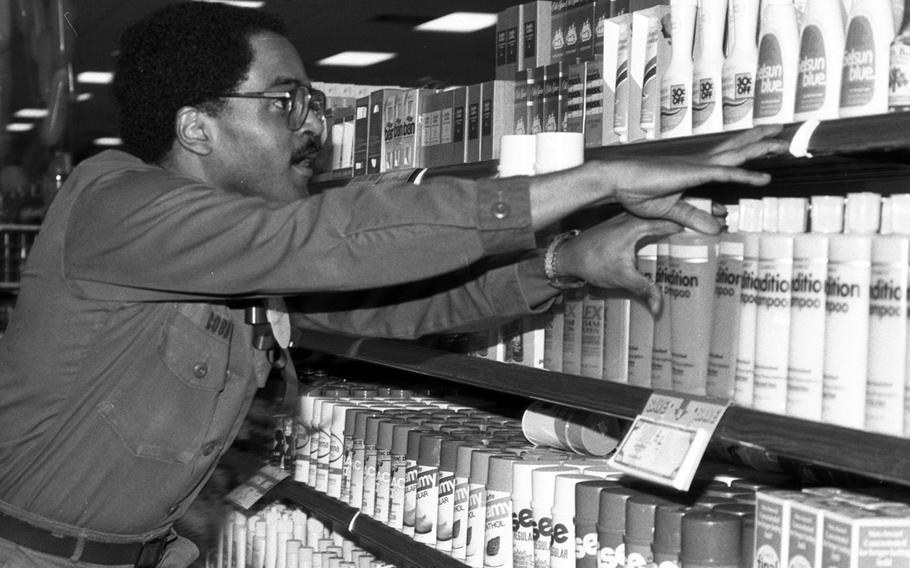 Staff Sgt. Stanley Cobb reaches for groceries during the shopping spree at the Aschaffenburg Commissary in 1981.