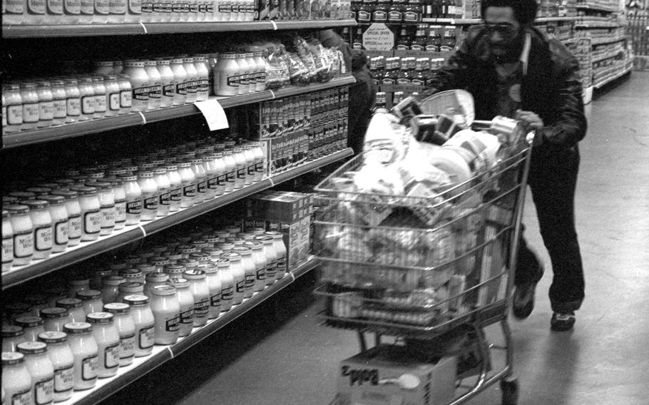 A participant in the shopping spree at the Aschaffenburg Commissary in 1981 races for the checkout.