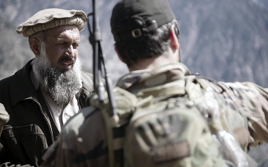 An Afghan National Army commando and a local security force commander discuss insurgent activity during a mission in Nuristan province, Afghanistan, April 12, 2012.