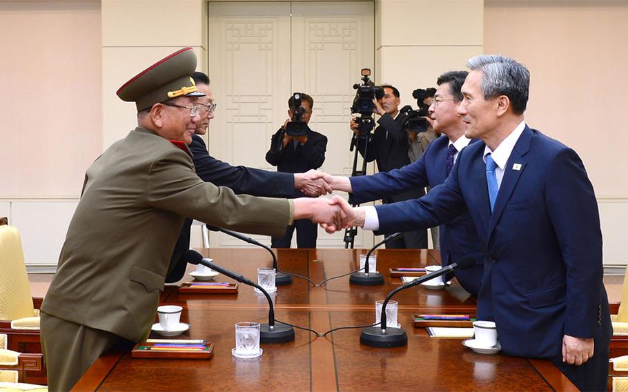 In this photo provided by the South Korean Unification Ministry, South Korean National Security Director, Kim Kwan-jin, right, and Unification Minister Hong Yong-pyo, second from right, shake hands with Hwang Pyong So, left, North Korea' top political officer for the Korean People's Army, and Kim Yang Gon, a senior North Korean official responsible for South Korean affairs, during their meeting at the border village of Panmunjom in Paju, South Korea, Saturday, Aug. 22, 2015. South Korea and North Korea agreed Saturday to hold their first high-level talks in nearly a year at a border village to defuse mounting tensions that have pushed the rivals to the brink of a possible military confrontation.