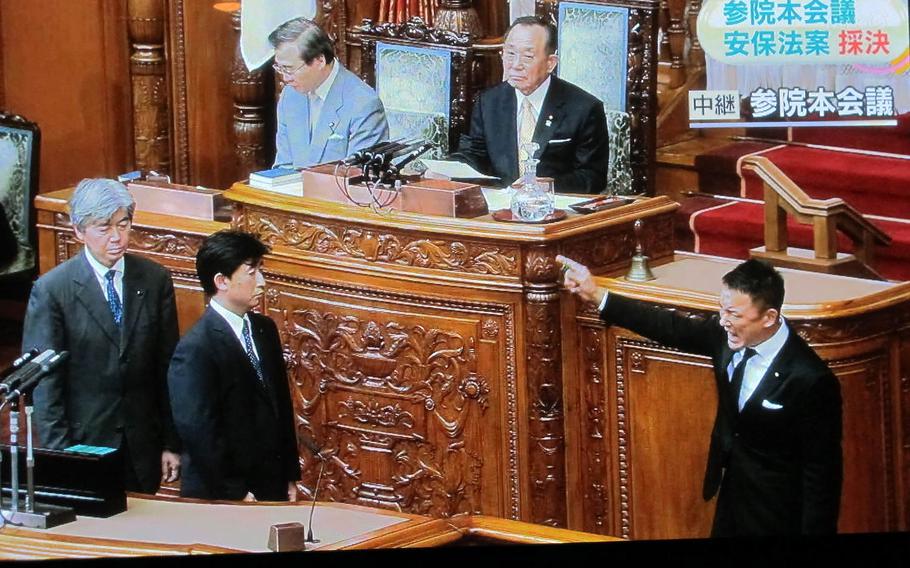 Opposition lawmaker Taro Yamamoto, right, shouts before casting his early morning vote during Japan Diet proceedings on Sept. 19, 2015. Lawmakers enacted a series of bills broadening Japan's defense powers, despite protests.