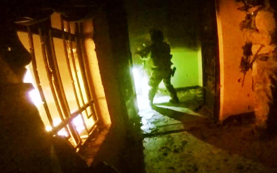 This image made from video taken on Thursday, Oct. 22, 2015 from a helmet camera shows U.S. and Iraqi special forces freeing hostages from a prison controlled by Islamic State militants in the town of Huwija.