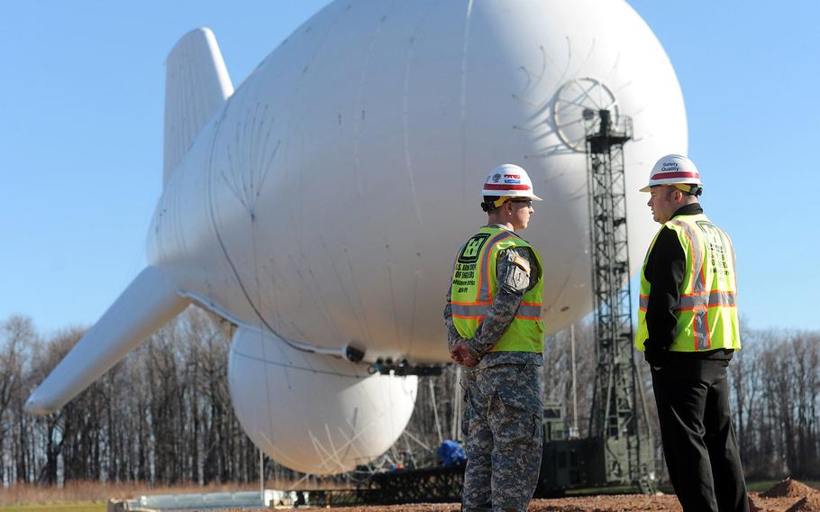 In a December, 2014 file photo, Army Capt. Dave MacPhail, left, and Jeff Crosse, project manager for the United States Army Corps of Engineers, talk on the site where one of the JLENS (Joint Land Attack Cruise Missile Defense Elevated Netted Sensor System) blimps is tethered at Aberdeen Proving Ground.