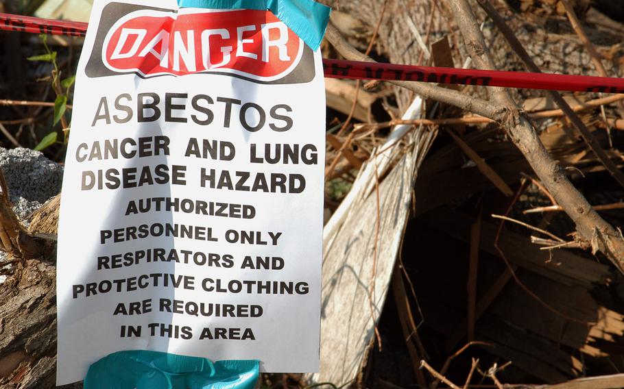 A sign warns of hazardous material as U.S. Army Corps of Engineers manage debris removal operations in Joplin, Mo., on July 29, 2011, following a deadly tornado in May 2011. A bill passed by the House in January 2016 would hand the asbestos industry a key legal advantage when fighting the claims of terminally ill veterans, critics of the legislation say.