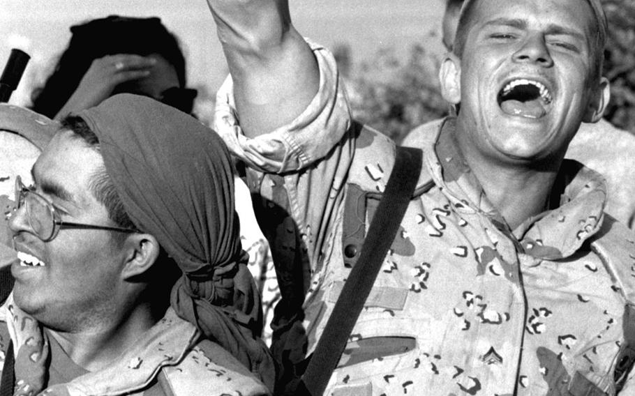 A U.S. Marine raises a fist in victory during the liberation of Kuwait.