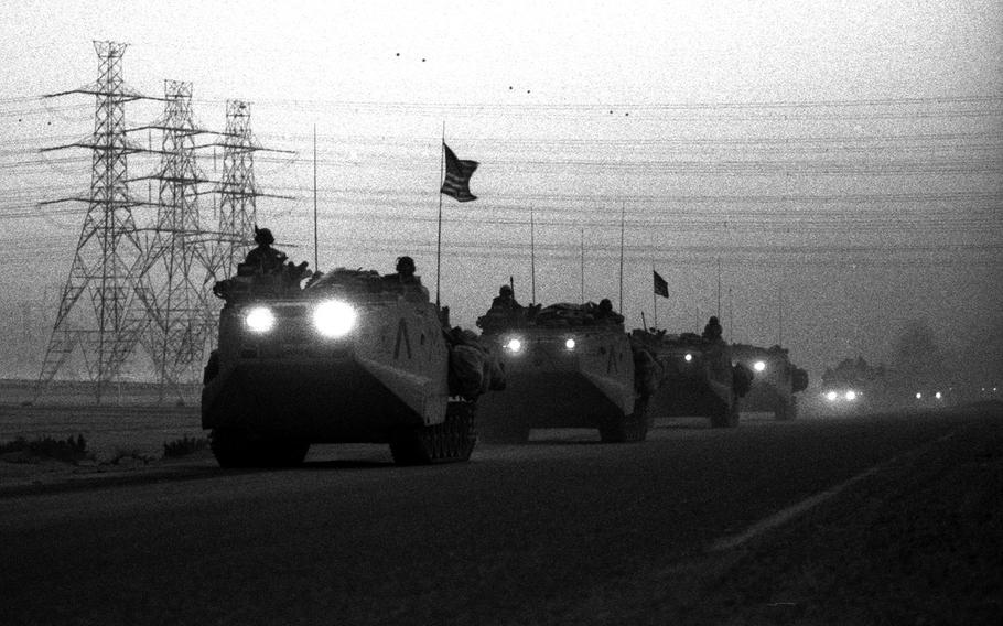 A U.S. Marine convoy makes its way through the desert dust and smoke from oil-well fires during the liberation of Kuwait from Iraqi forces at the end of the Gulf War.
