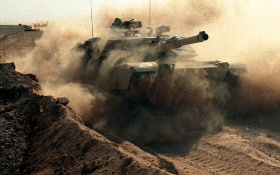 In February, 1991, an Abrams tank from the 2nd Armored Cavalry Regiment roars through a breached sand berm separating Saudi Arabia from Iraq, paving the way for advancing allied troops as the Gulf War moves to its next phase after 38 days of air raids and skirmishes. The ground forces preparing to recapture Kuwait from Saddam Hussein's occupation reportedly consisted of 700,000 troops, 530,000 of them from the U.S.