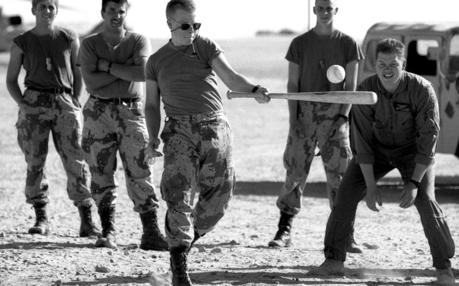 Soldiers from 4th Squadron, 2nd Armored Cavalry Regiment play a game of "Saudi ball" to ease stress and occupy some of their free time in the Saudi desert in February, 1991. The game they invented is like baseball, except that everyone has to bat one-handed with the hand they normally don't use; pitchers and fielders must also throw with their "other" hand.