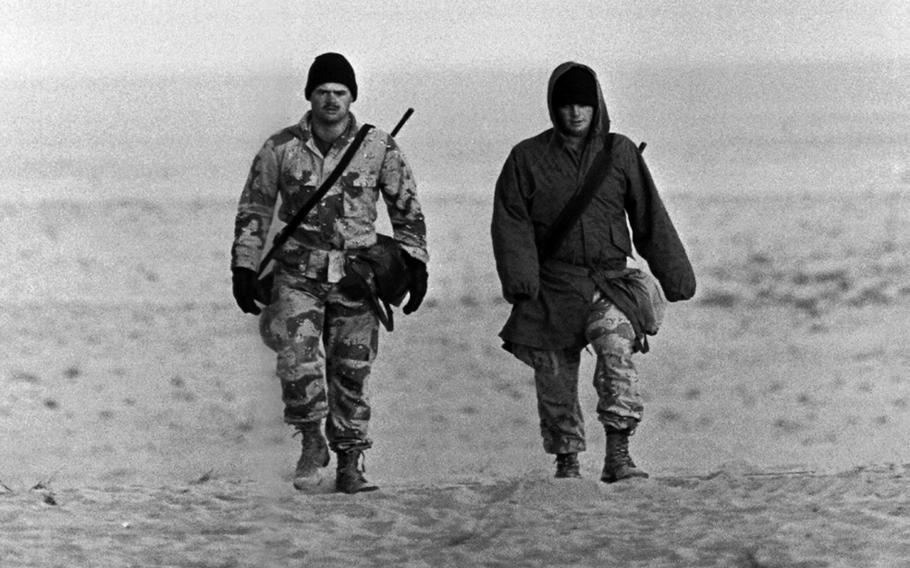 Two servicemembers in Saudi Arabia during Operation Desert Shield in January, 1991 demonstrate that "desert" doesn't necessarily mean "hot," especially in January.