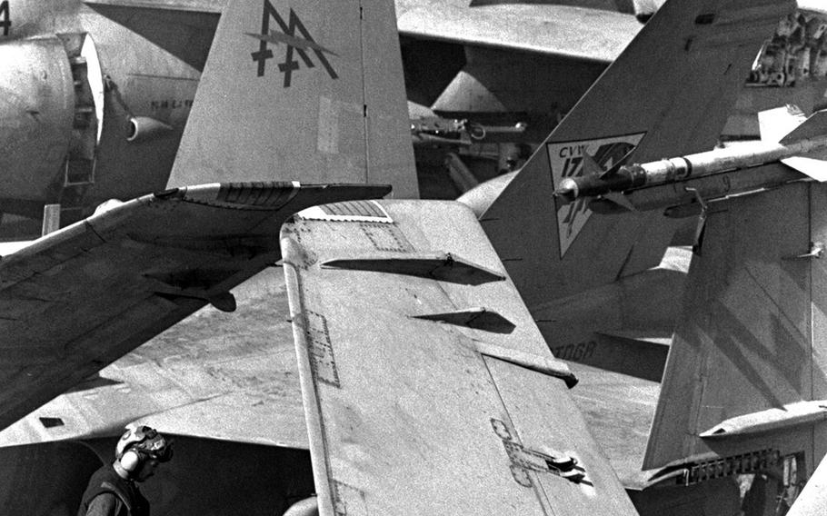 A flight deck crewman walks amid the jumble of aircraft wings on board the
USS Saratoga, stationed in the Red Sea, in December, 1990..