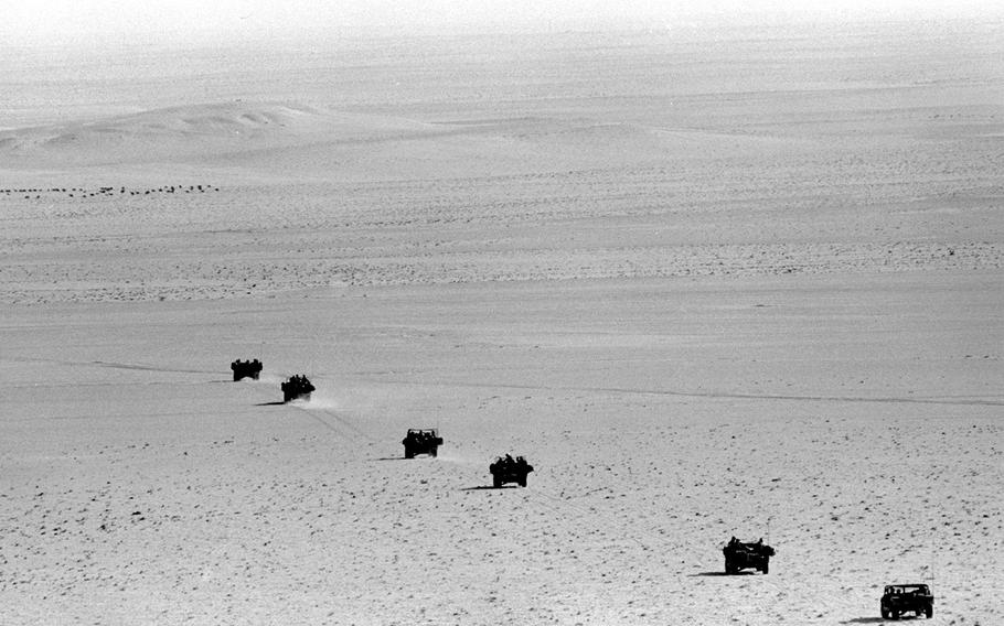 A line of trucks files across the desert during an Army Special Forces exercise in eastern Saudi Arabia in December, 1990.