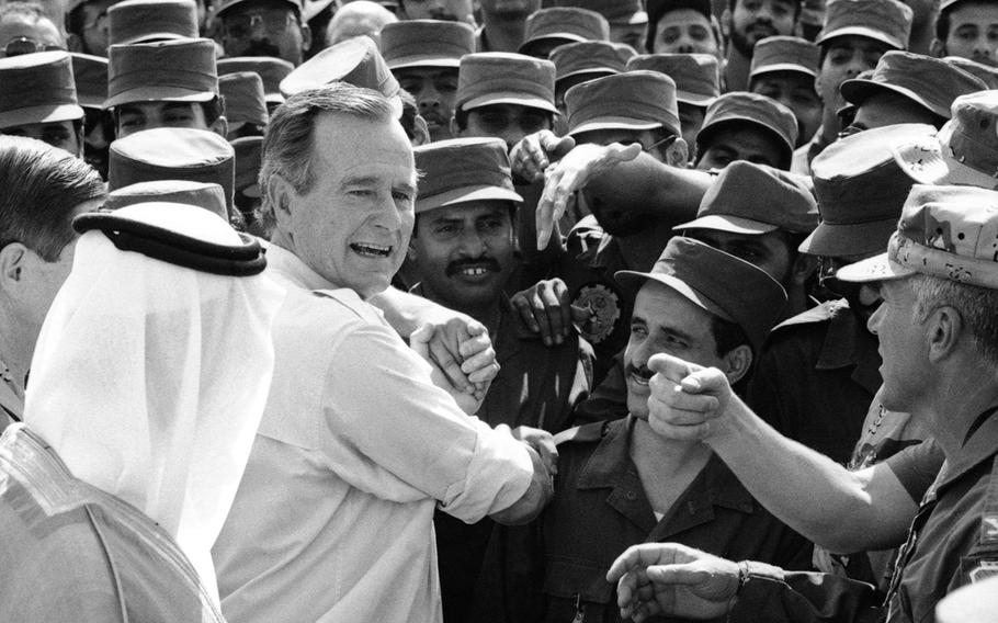 President George H.W. Bush meets U.S. troops in Saudi Arabia during Operation Desert Shield in November, 1990.